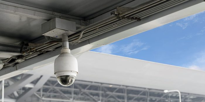 Closeup CCTV cameras on the roof with blue sky background.